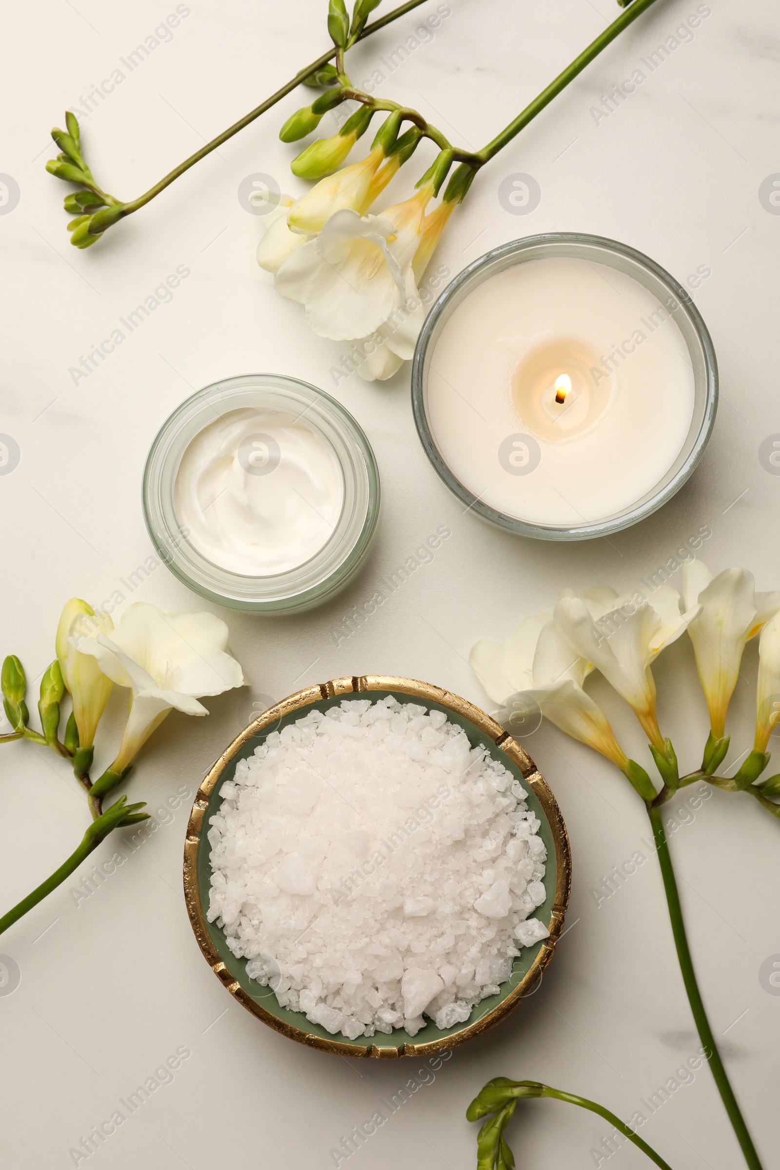 Photo of Flat lay composition with different spa products and flowers on white marble table