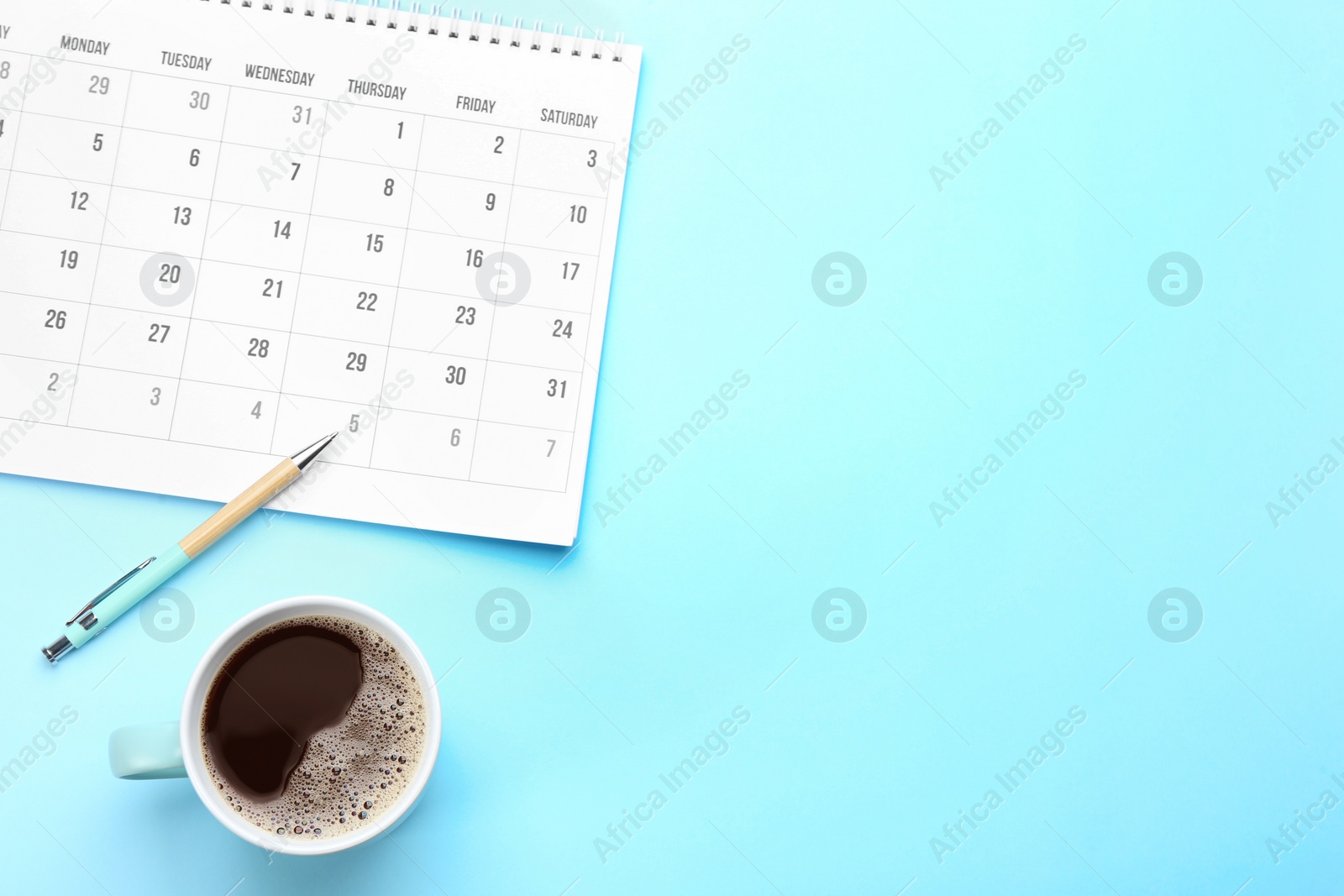 Photo of Flat lay composition with calendar on light blue background. Space for text