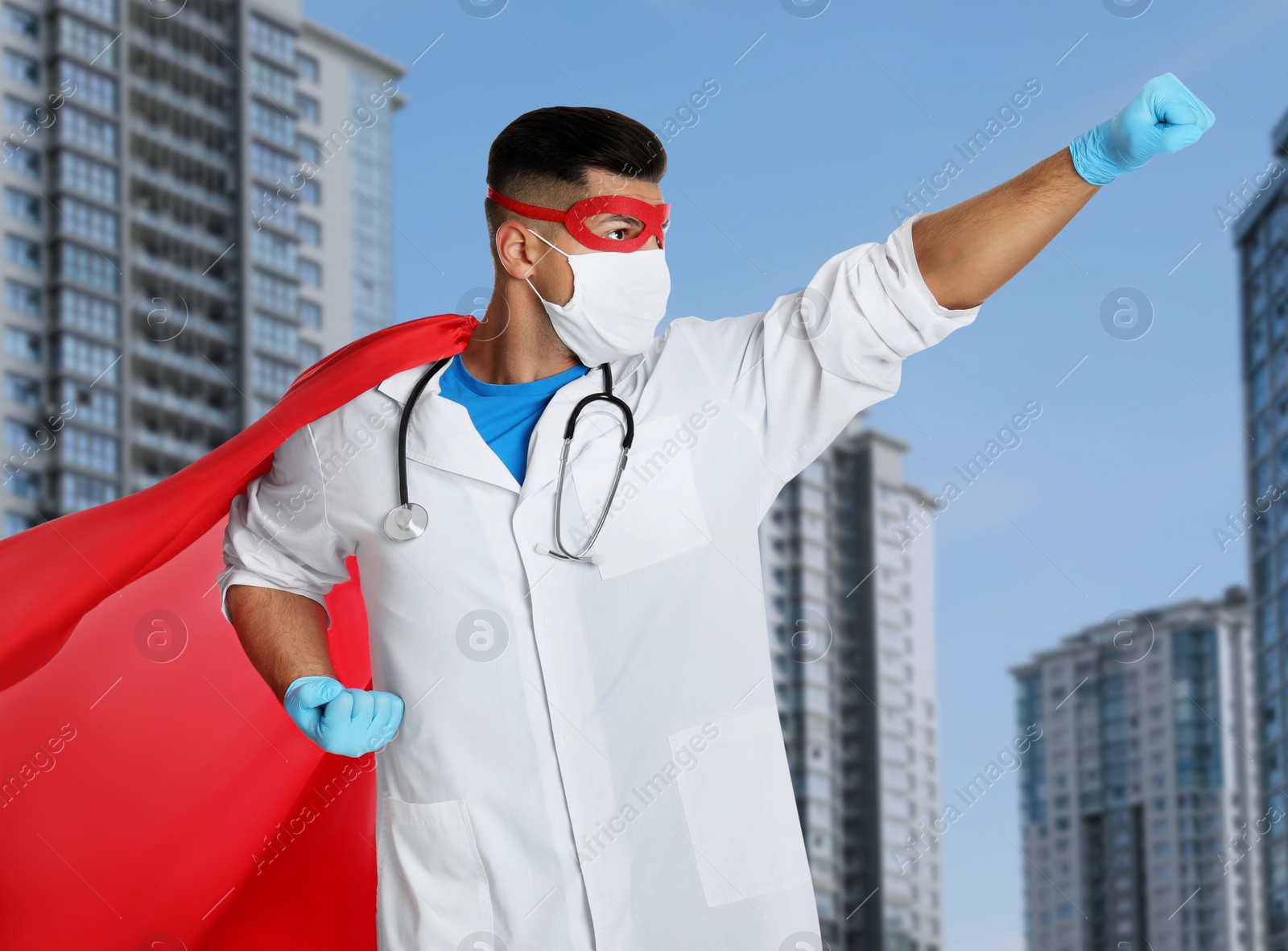 Image of Doctor dressed as superhero on city background. Medical workers fighting with dangerous diseases