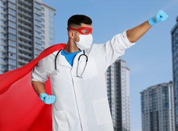 Doctor dressed as superhero on city background. Medical workers fighting with dangerous diseases