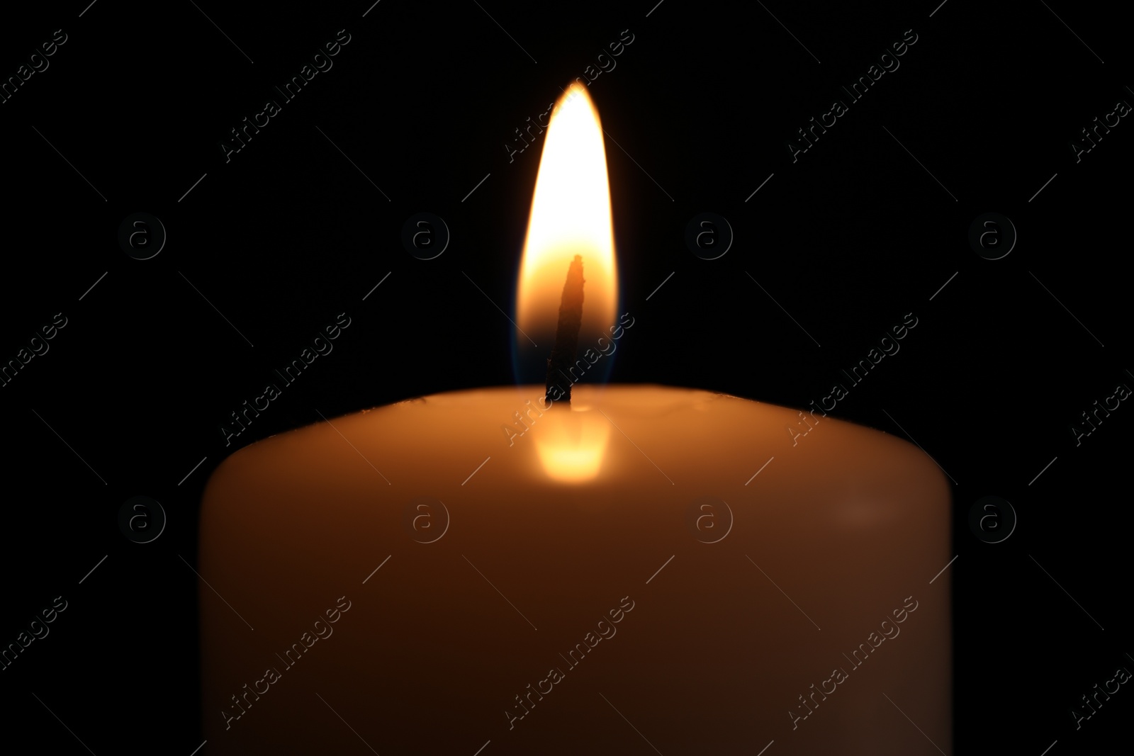 Photo of Burning candle in darkness, closeup. Memory day