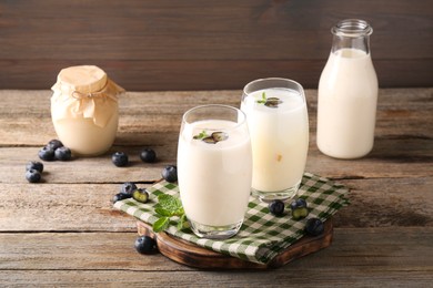 Tasty yogurt and blueberries on wooden table