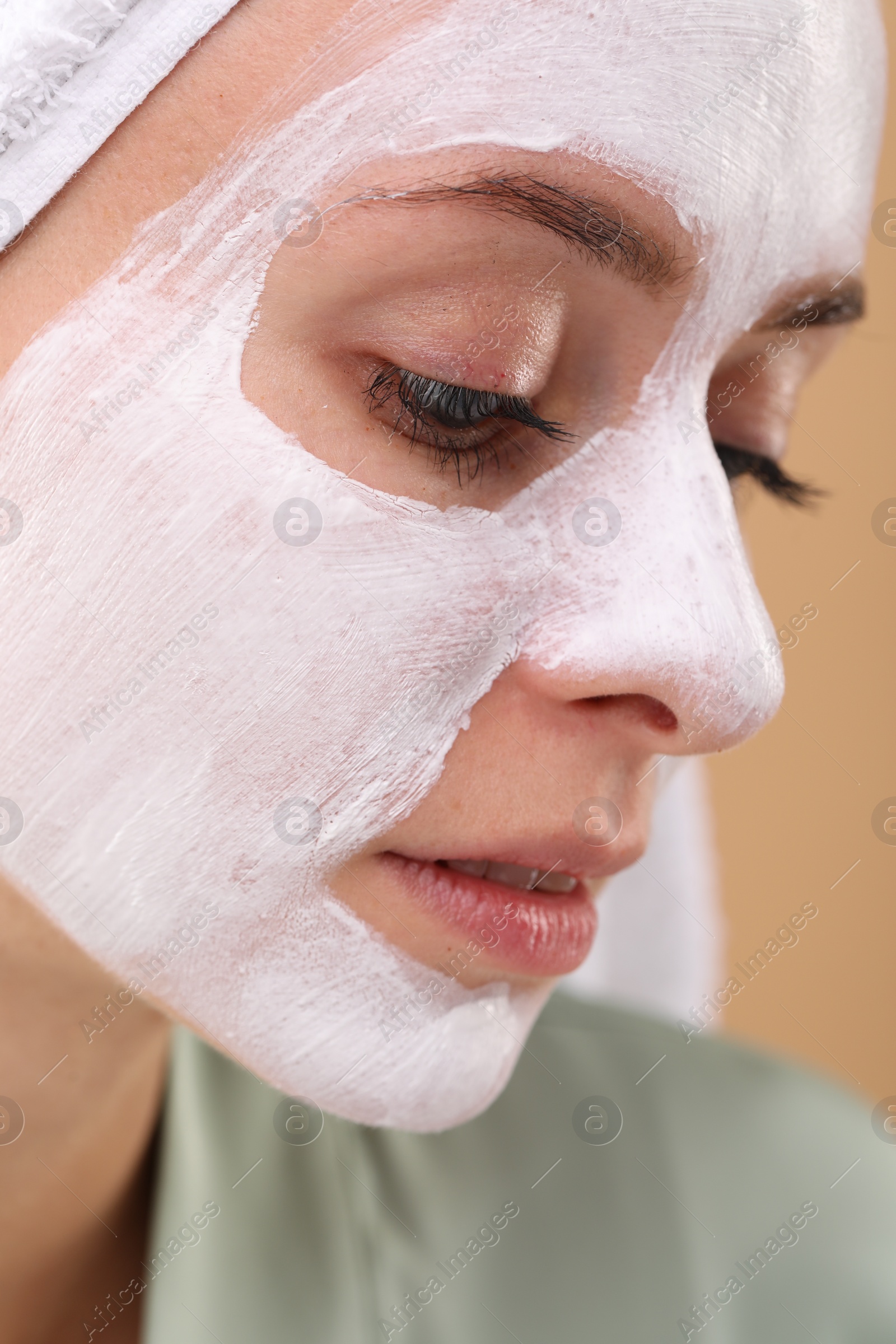 Photo of Woman with face mask on beige background, closeup. Spa treatments