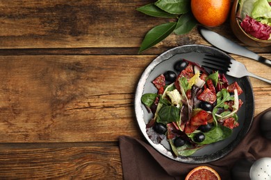 Photo of Delicious salad with sicilian orange served on wooden table, flat lay. Space for text