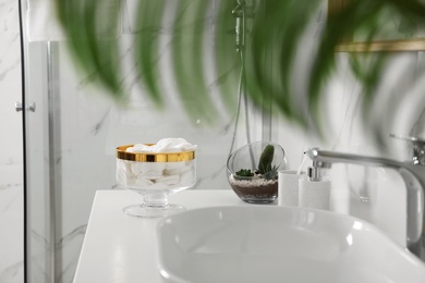 Photo of Jar with cotton pads on bathroom countertop