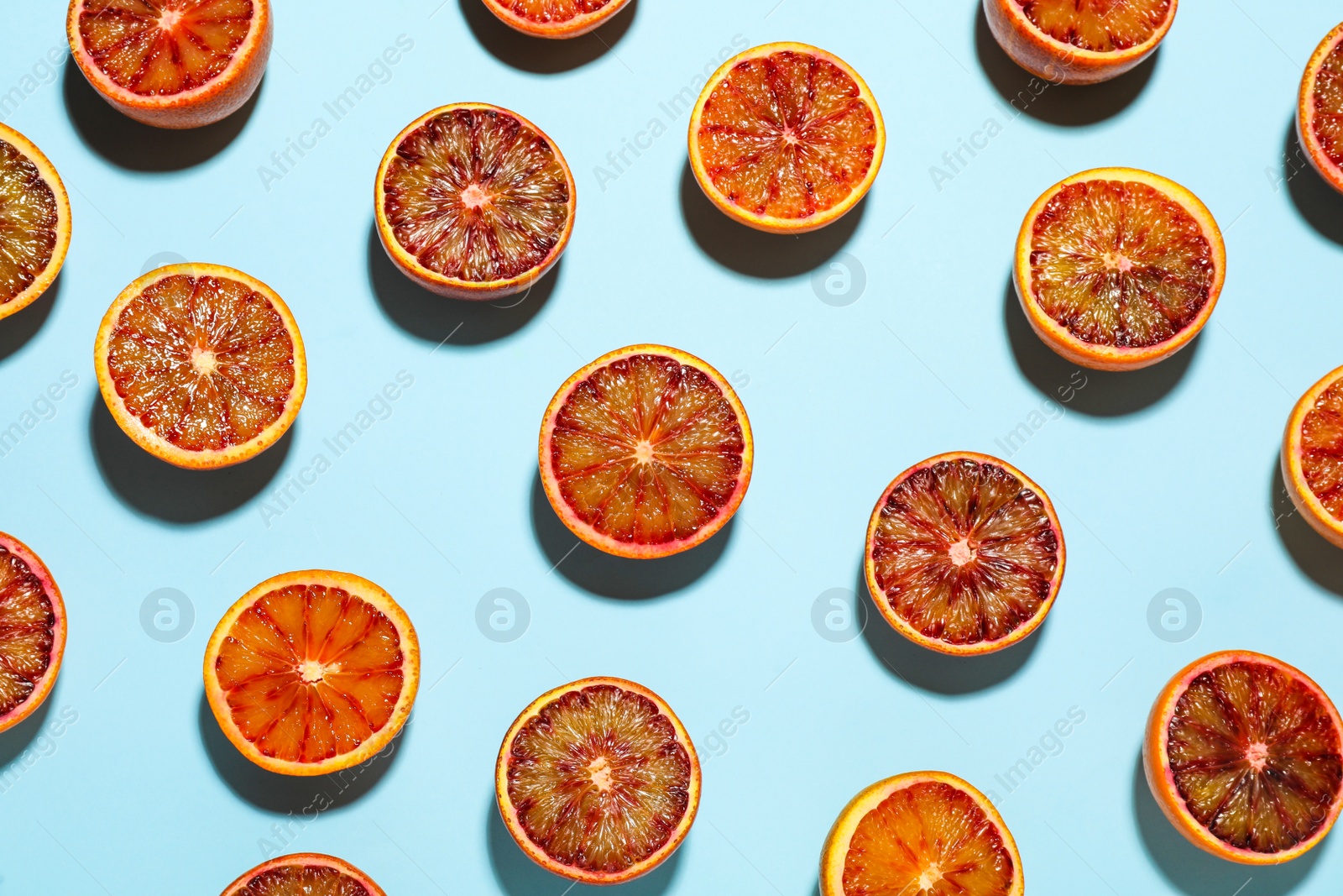 Photo of Many ripe sicilian oranges on light blue background, flat lay