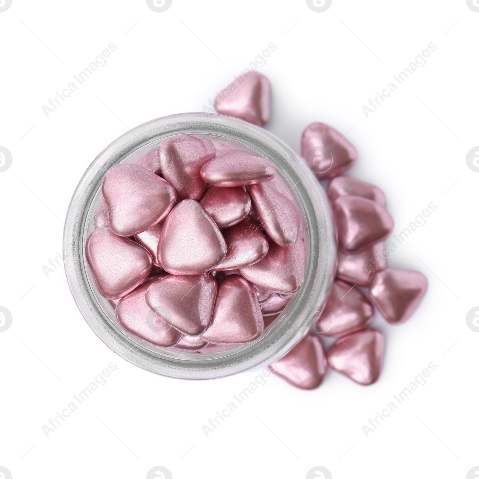 Photo of Glass jar and delicious heart shaped candies on white background, top view