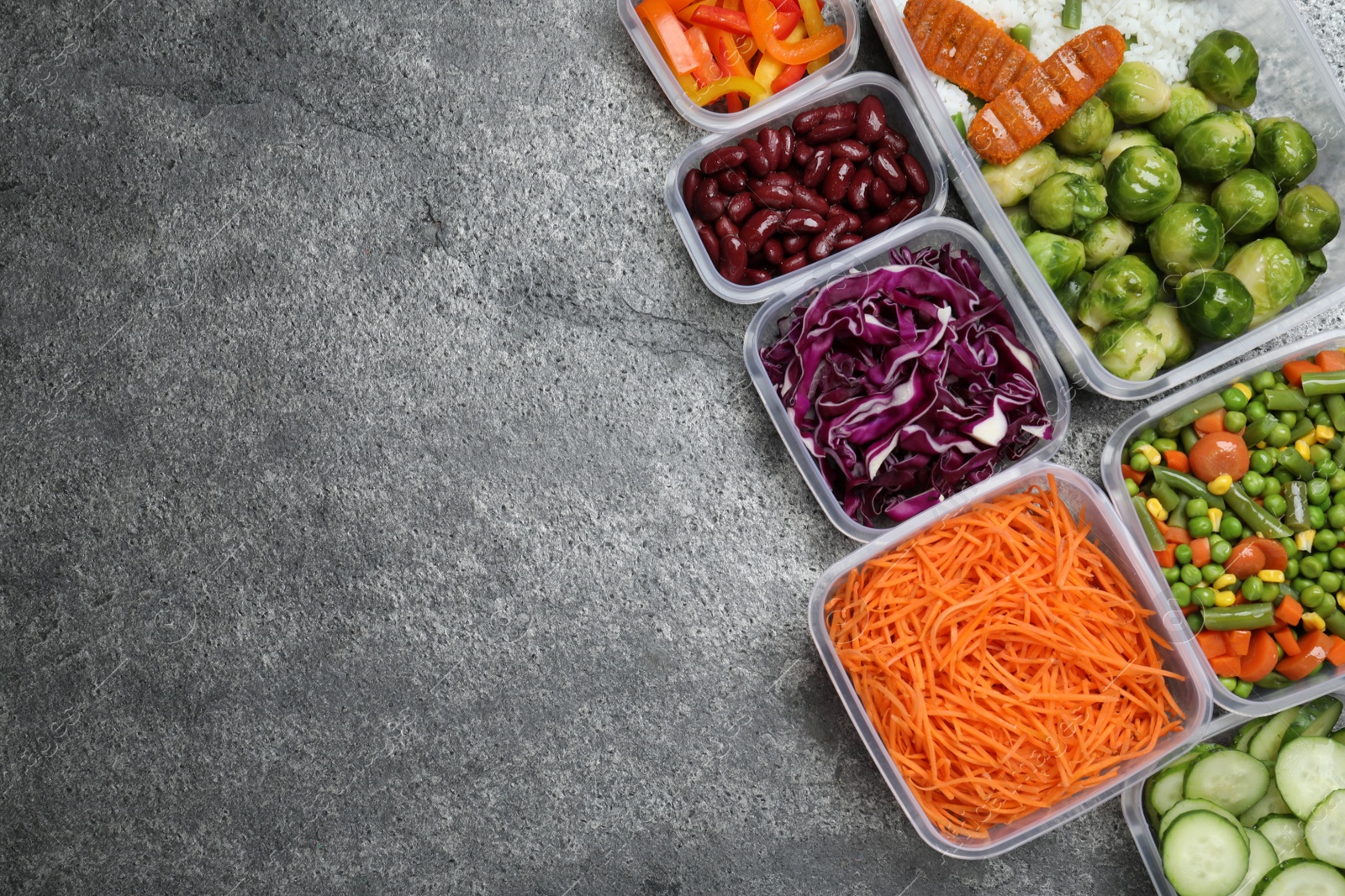 Photo of Set of plastic containers with fresh food on grey   table, flat lay. Space for text