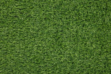 Green artificial grass as background, top view