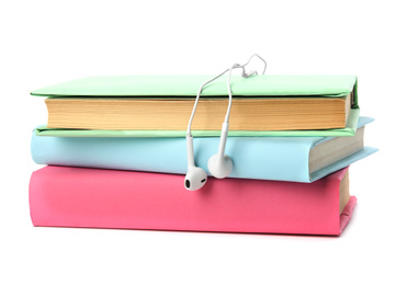 Photo of Stack of books and earphones isolated on white