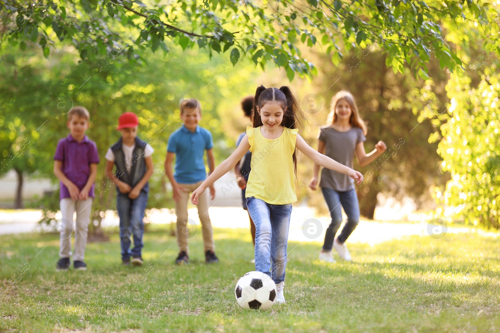 Photo of Cute little children playing with ball outdoors on sunny day