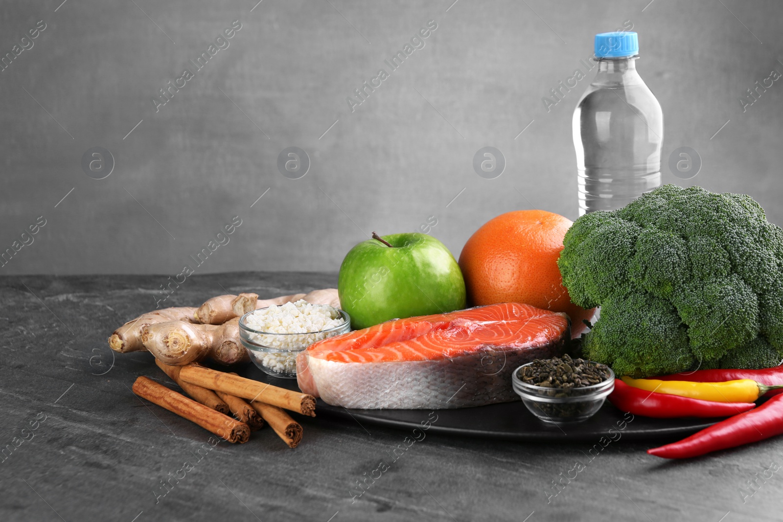 Photo of Metabolism. Different food products on grey table, space for text