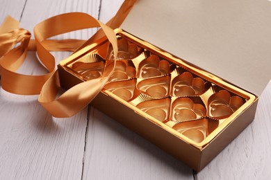 Photo of Empty box of chocolate candies on white wooden table