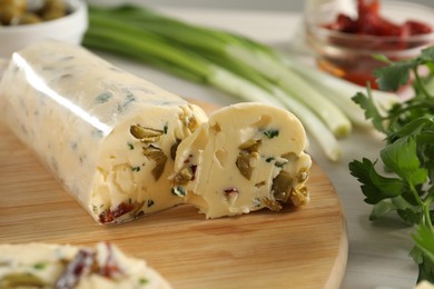 Photo of Tasty butter with olives, green onion and parsley on table, closeup