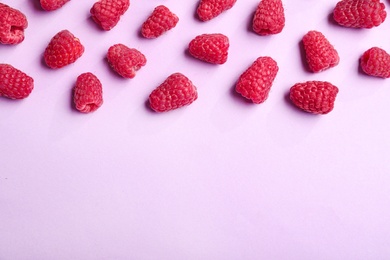 Photo of Tasty ripe juicy raspberries on pink background, top view with space for text