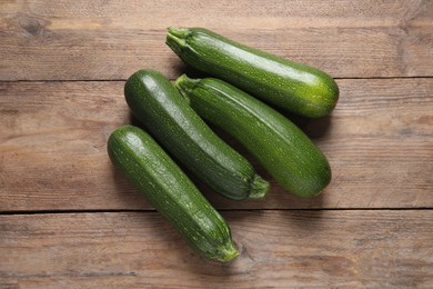 Photo of Raw ripe zucchinis on wooden table, flat lay