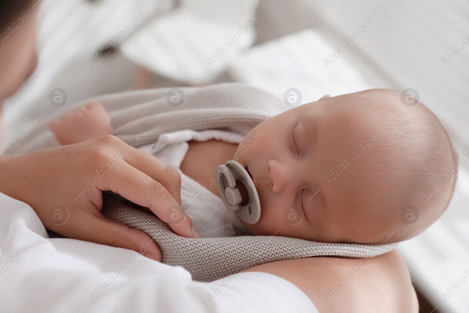 Photo of Mother holding her cute sleeping baby with pacifier, above view