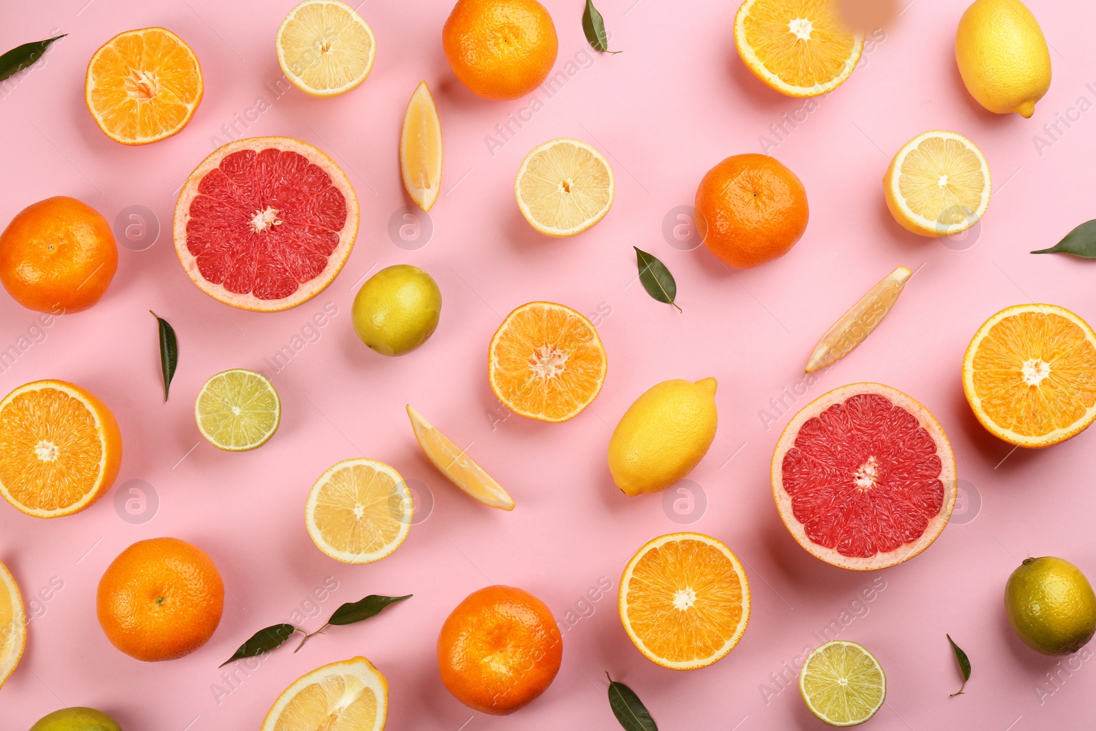 Photo of Flat lay composition with tangerines and different citrus fruits on pink background