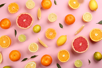 Photo of Flat lay composition with tangerines and different citrus fruits on pink background