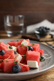 Photo of Delicious salad with watermelon, blueberries and feta cheese on wooden table, closeup