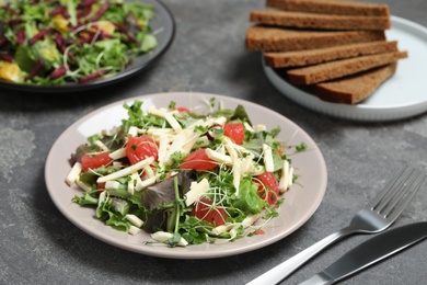 Photo of Delicious carrot salad served on grey table, closeup