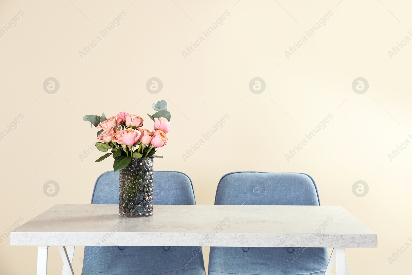 Photo of Vase with beautiful flowers as element of interior design on table in room. Space for text