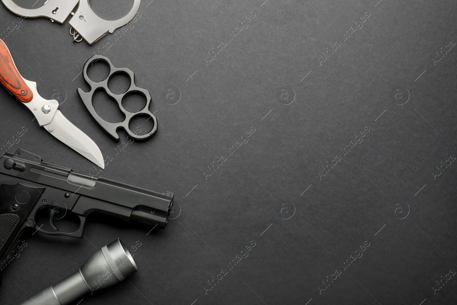 Photo of Flat lay composition with brass knuckles on black background. Space for text