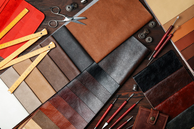 Photo of Flat lay composition with leather samples and tools on  wooden table