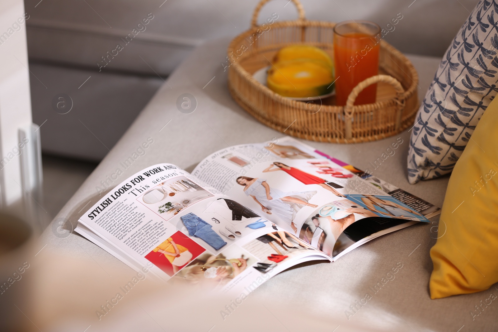 Photo of Open fashion magazine on sofa in living room