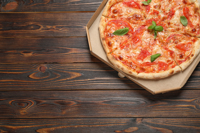 Photo of Delicious pizza Margherita on wooden table, top view. Space for text