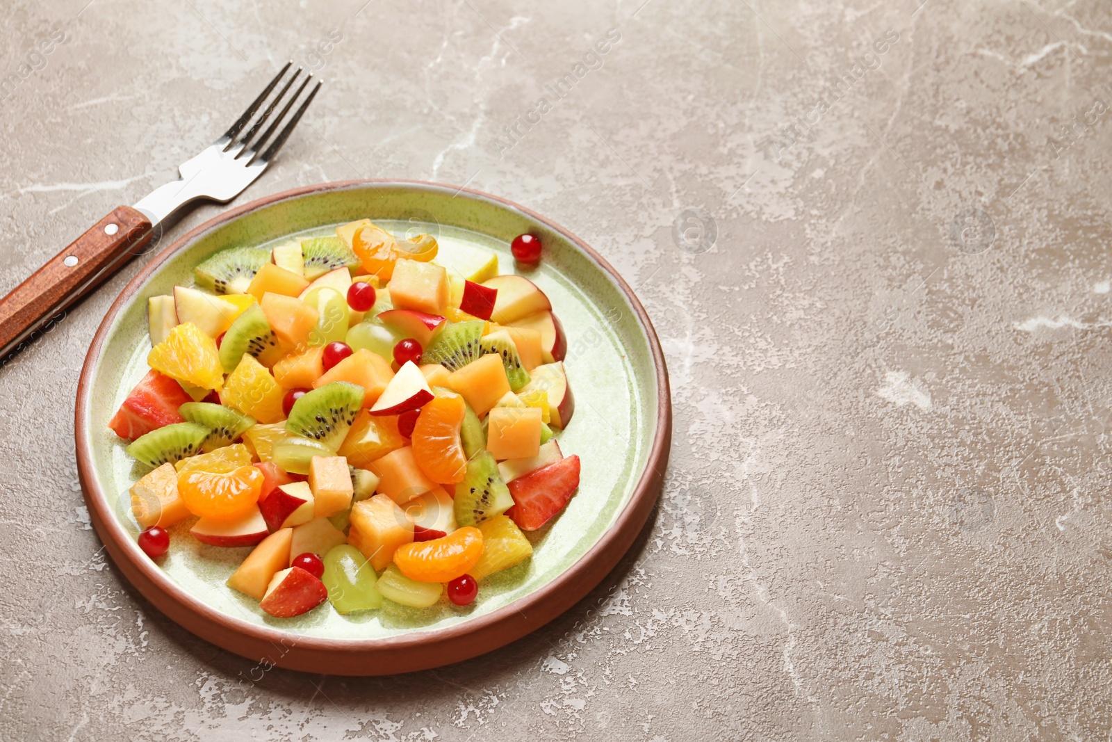 Photo of Plate with fresh cut fruits on table