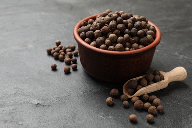 Photo of Dry allspice berries (Jamaica pepper) on black table, space for text