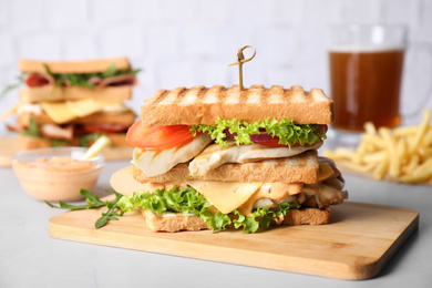 Photo of Tasty sandwich with chicken served on light table