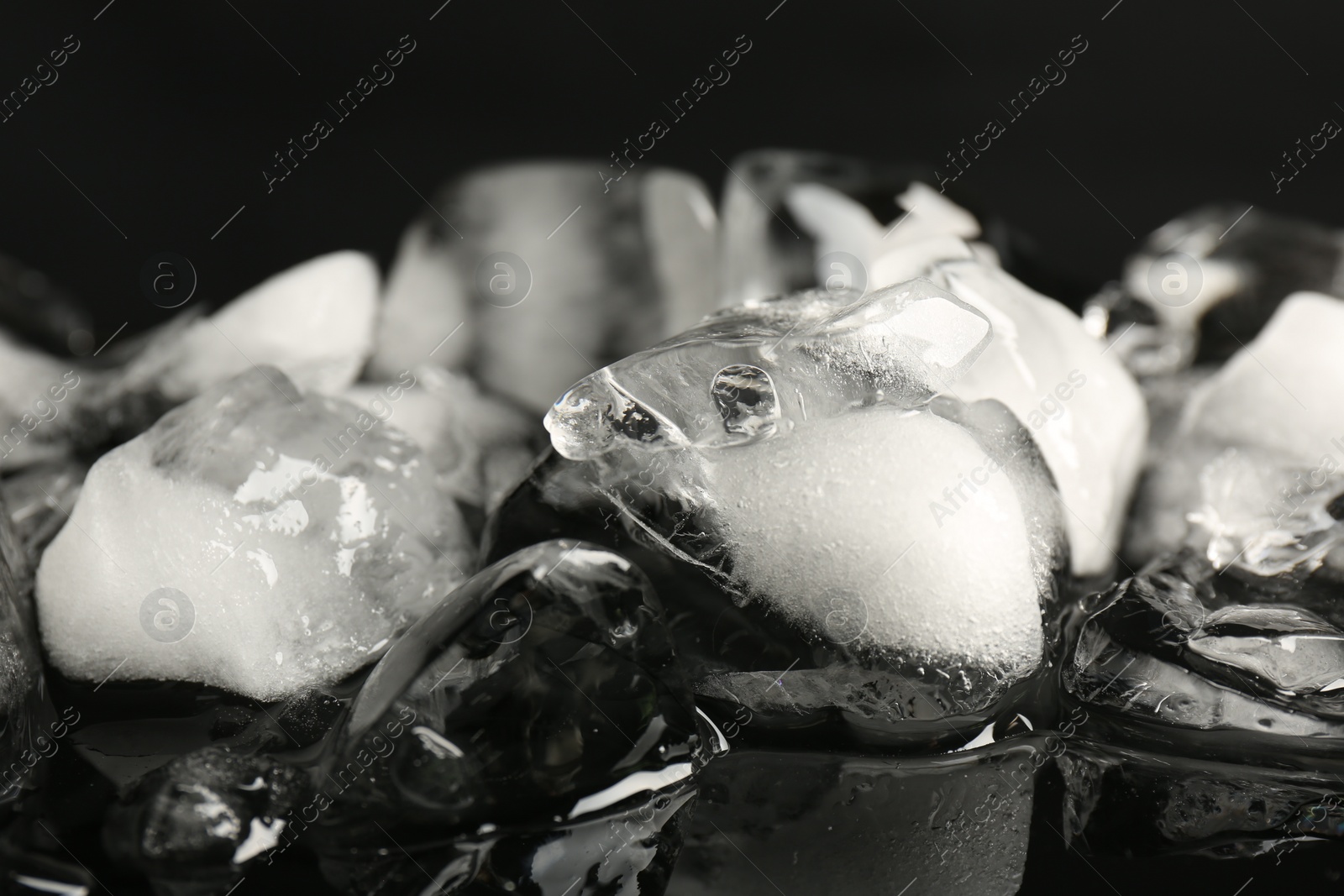 Photo of Pile of crushed ice on black mirror surface