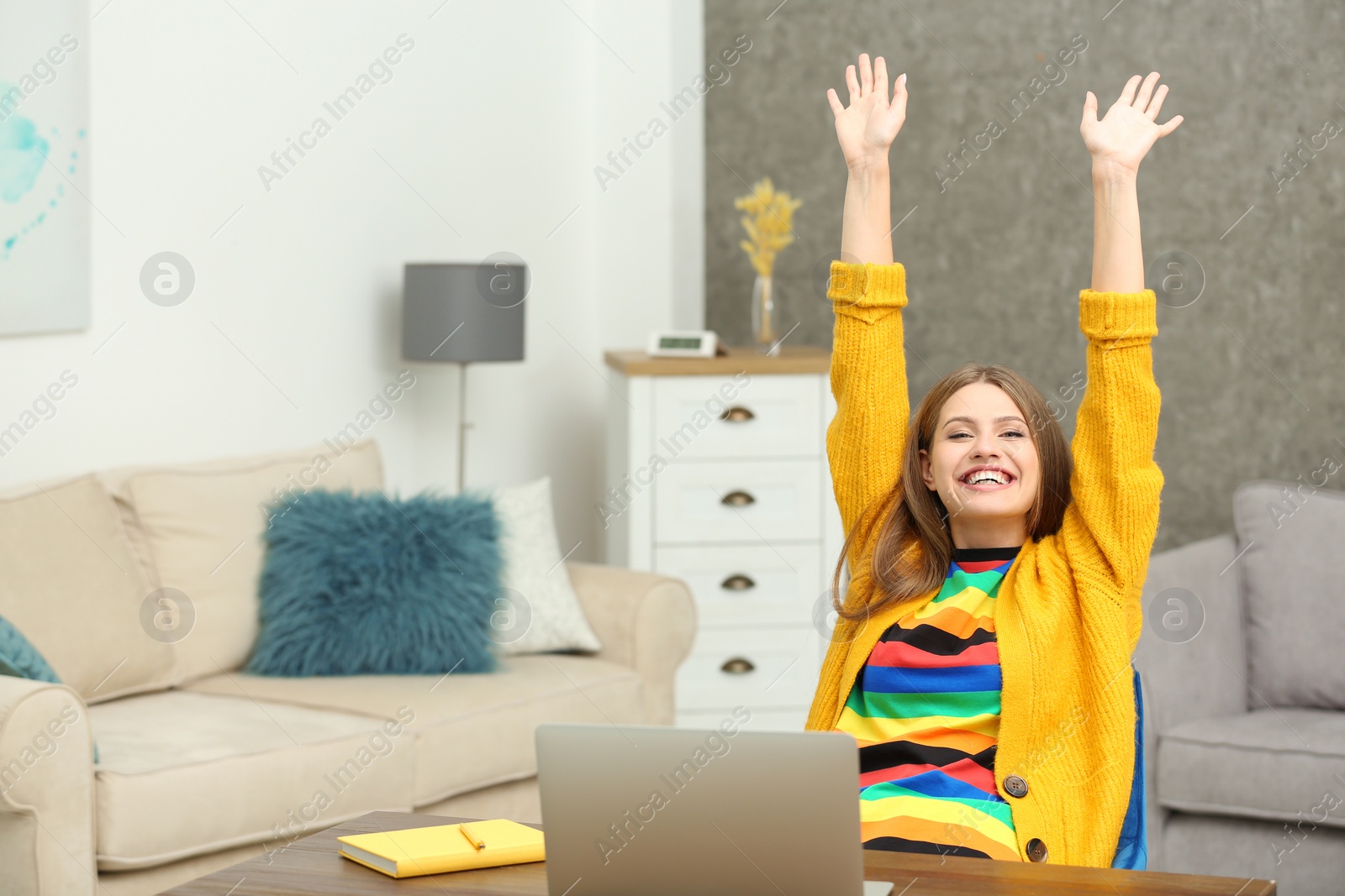 Photo of Happy young woman playing online lottery using laptop at home