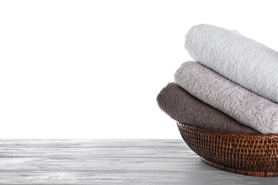 Photo of Fresh towels on wooden table against white background. Space for text