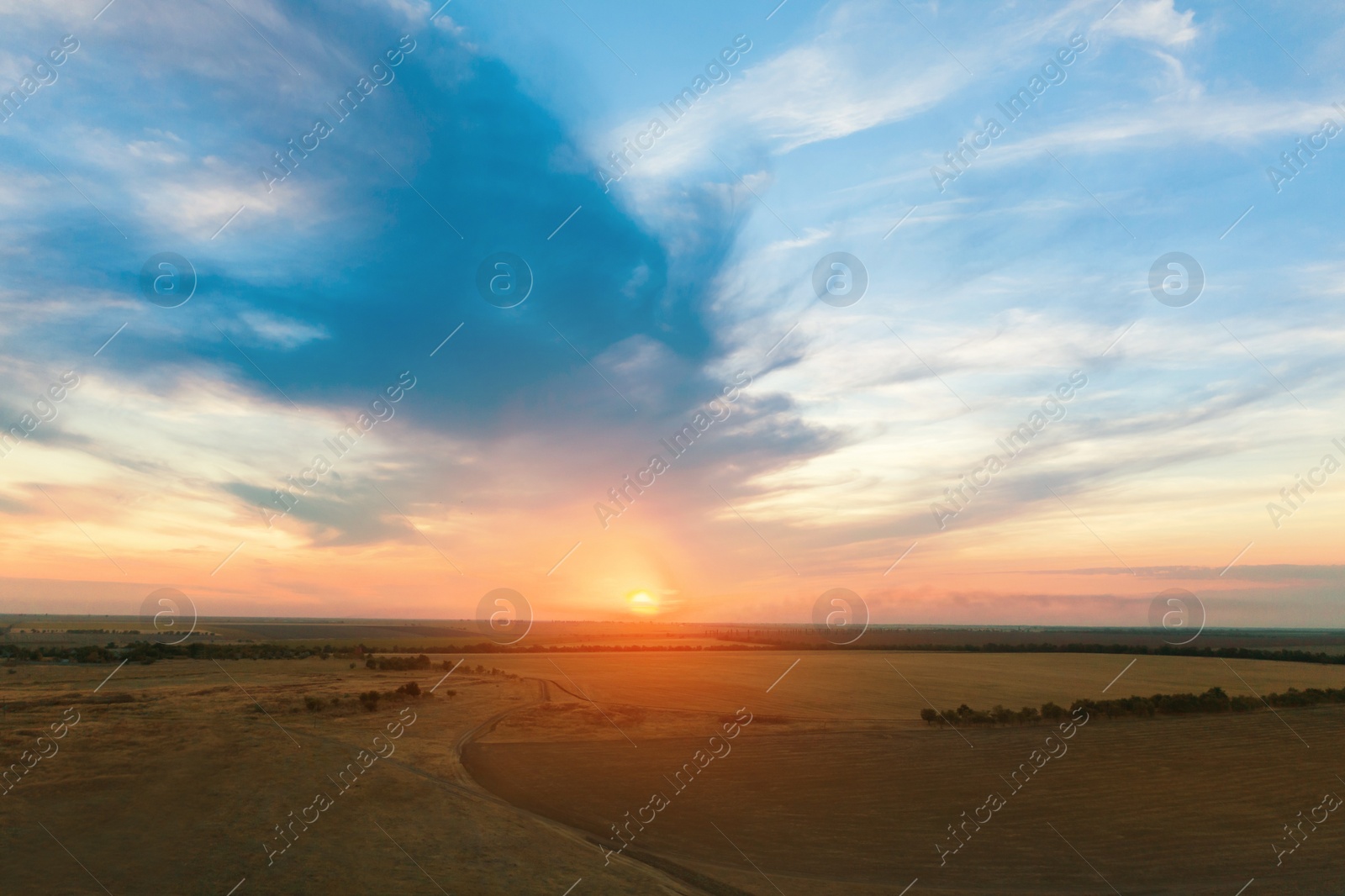 Image of Amazing cloudy sky over fields, aerial view. Sunset landscape