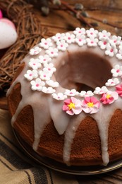 Photo of Delicious Easter cake decorated with sprinkles on wooden table, closeup