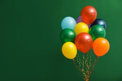 Photo of Bunch of bright balloons on color background, space for text. Celebration time