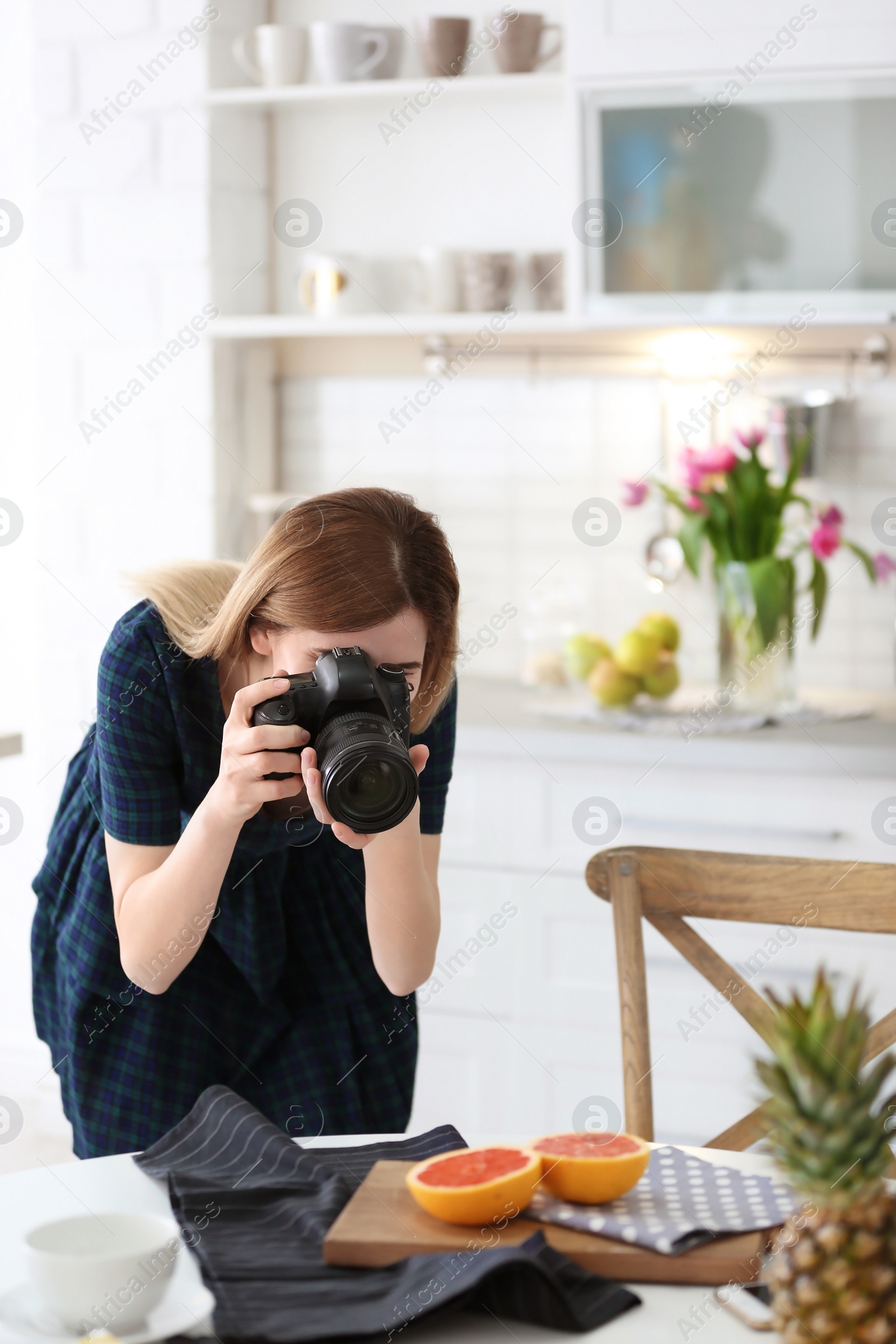 Photo of Young blogger taking photo of food in kitchen