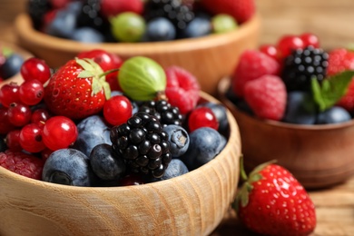 Photo of Mix of ripe berries in bowls, closeup