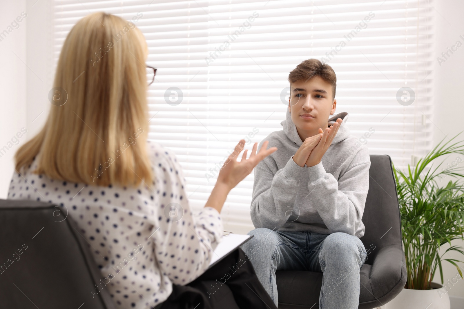 Photo of Psychologist working with teenage boy in office