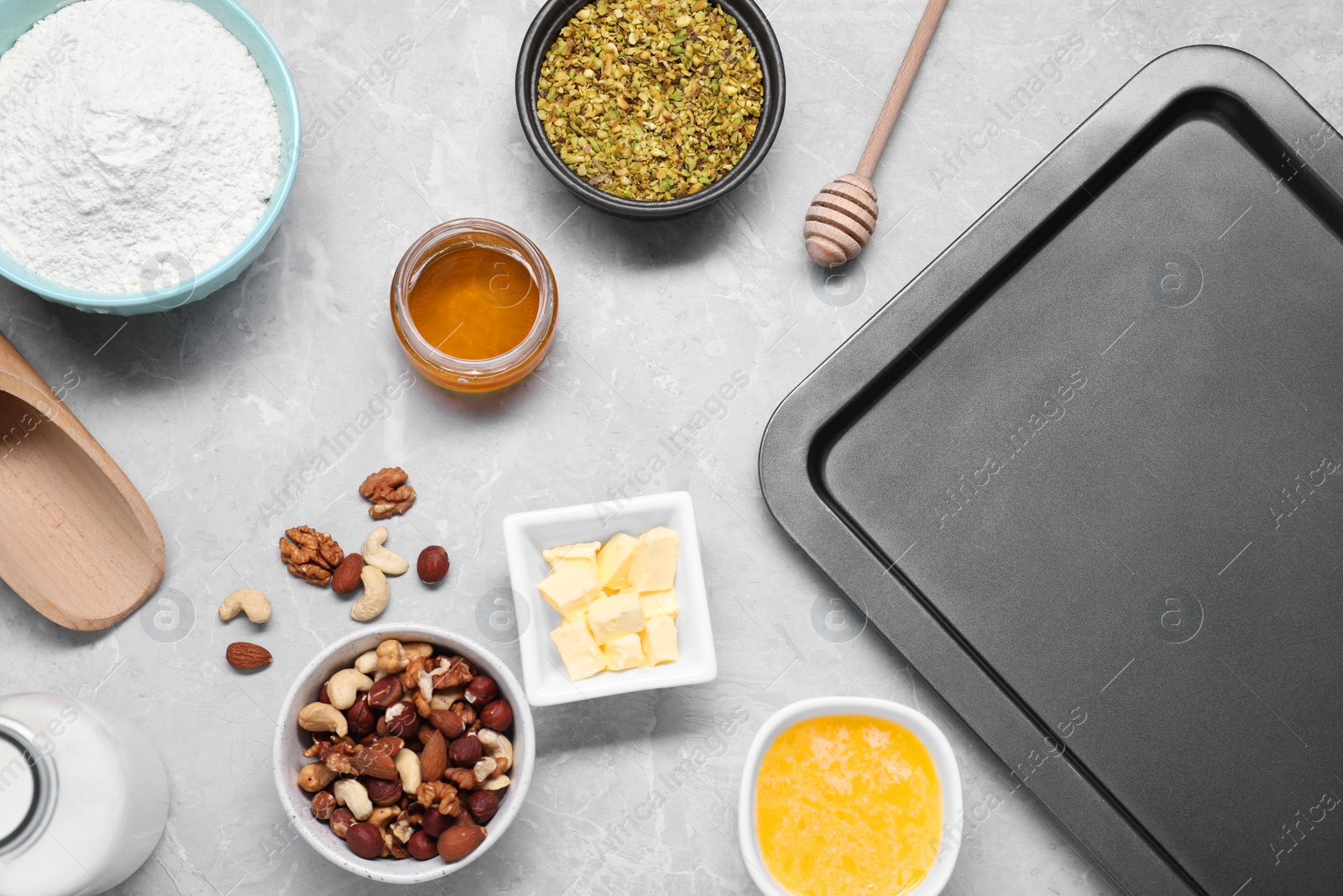 Photo of Different ingredients for making delicious baklava on grey textured table, flat lay