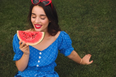 Photo of Beautiful young woman with watermelon on green grass outdoors