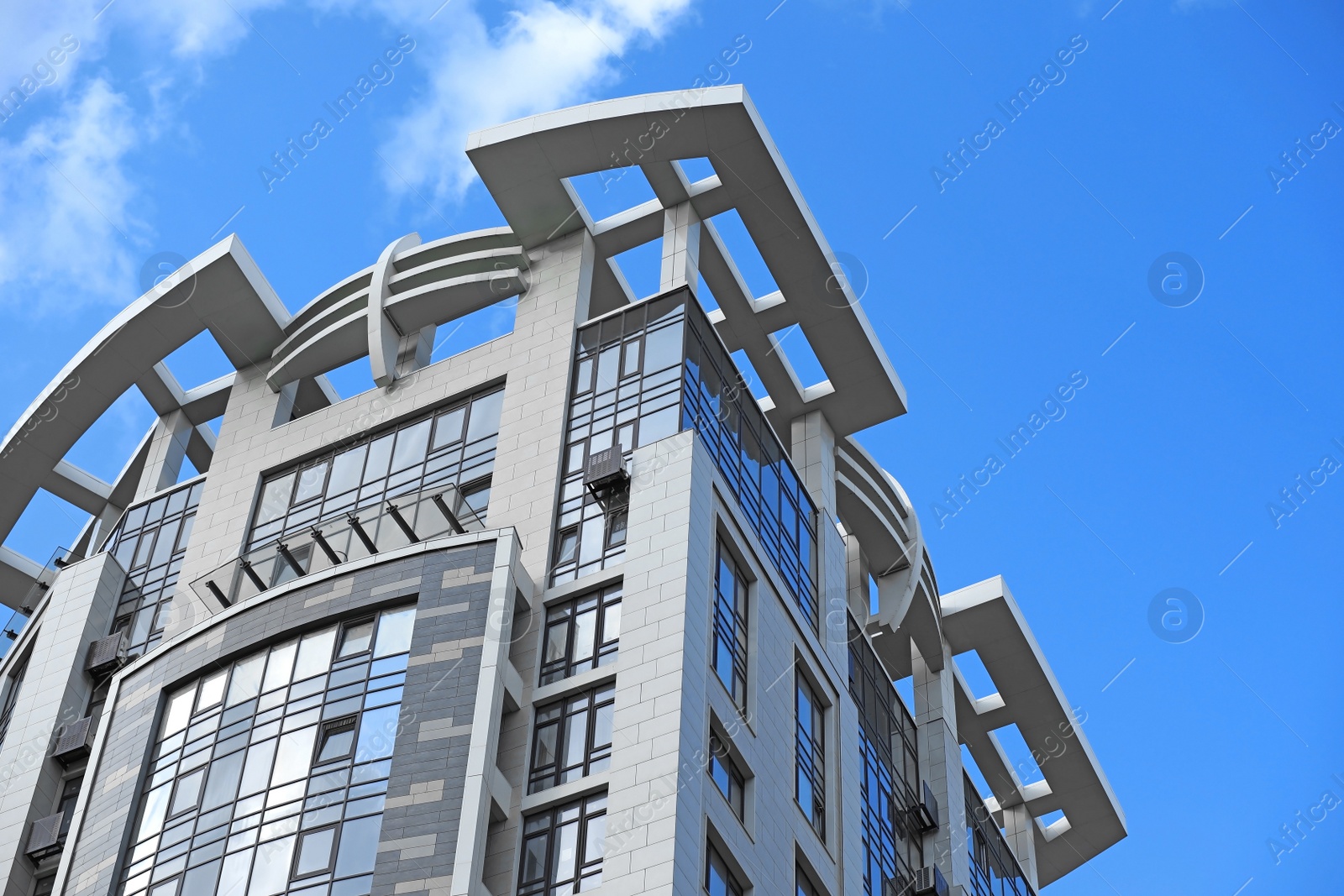 Photo of Low angle view of modern building against blue sky