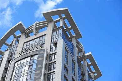 Photo of Low angle view of modern building against blue sky