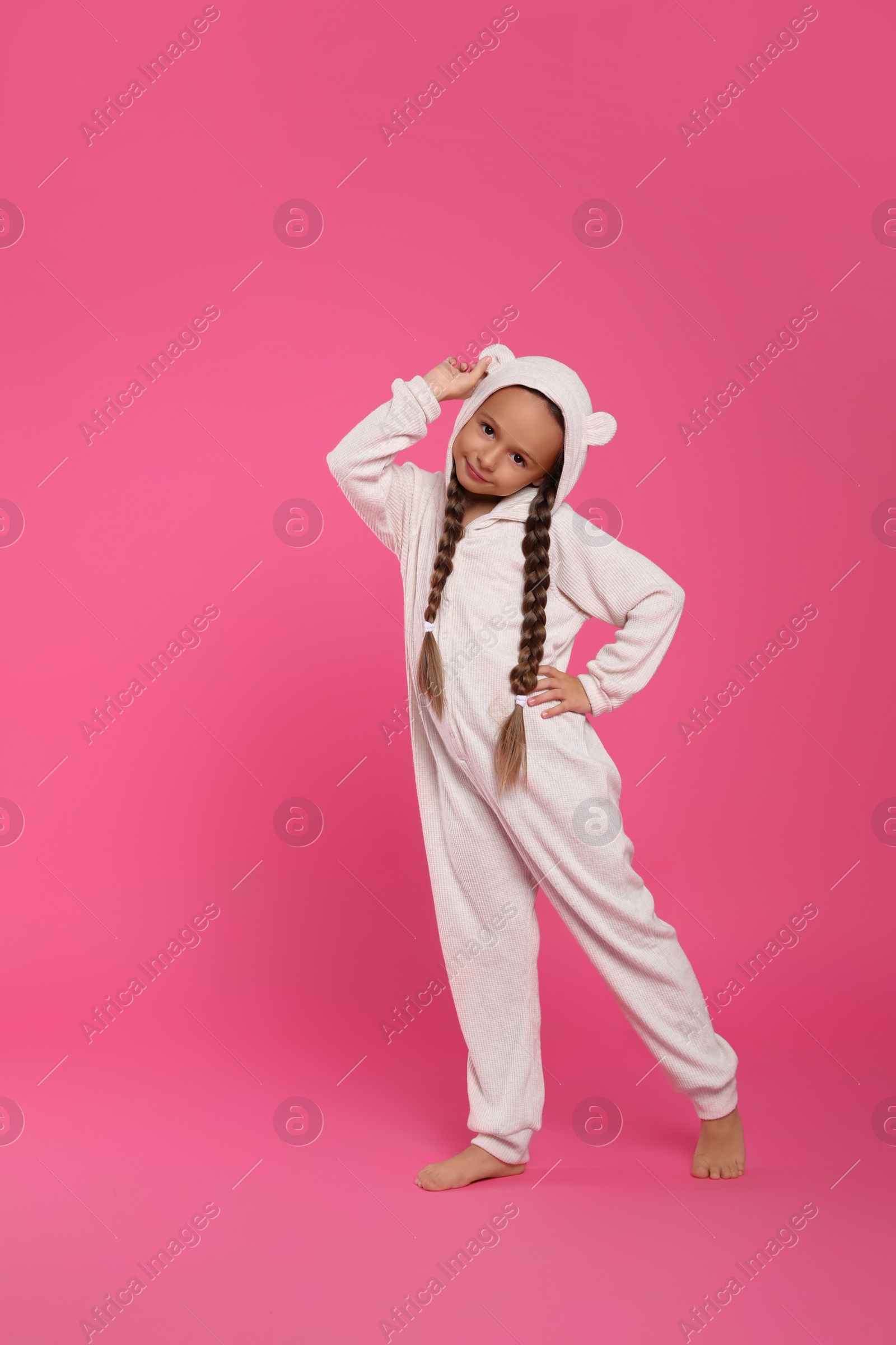 Photo of Cute girl wearing pajamas on pink background