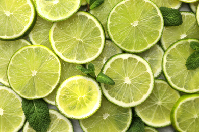 Photo of Slices of fresh juicy limes as background, top view