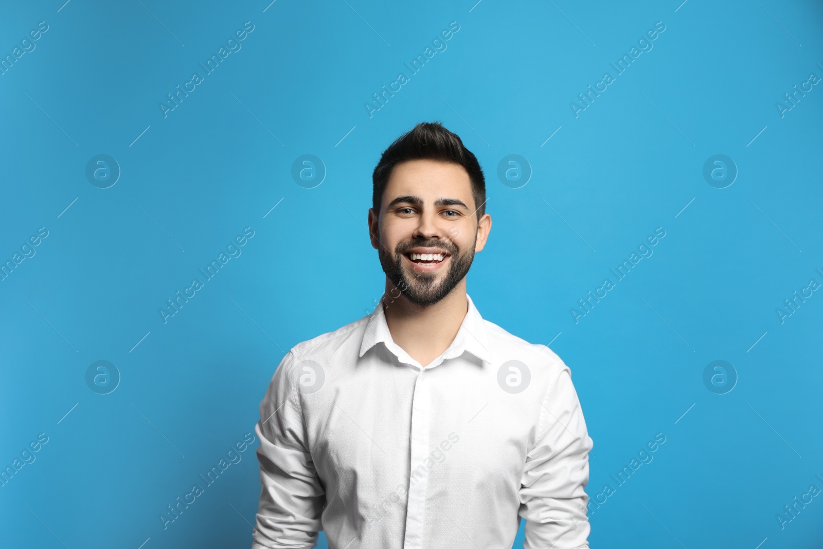 Photo of Young man laughing on light blue background. Funny joke