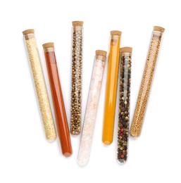 Glass tubes with different spices on white background, top view